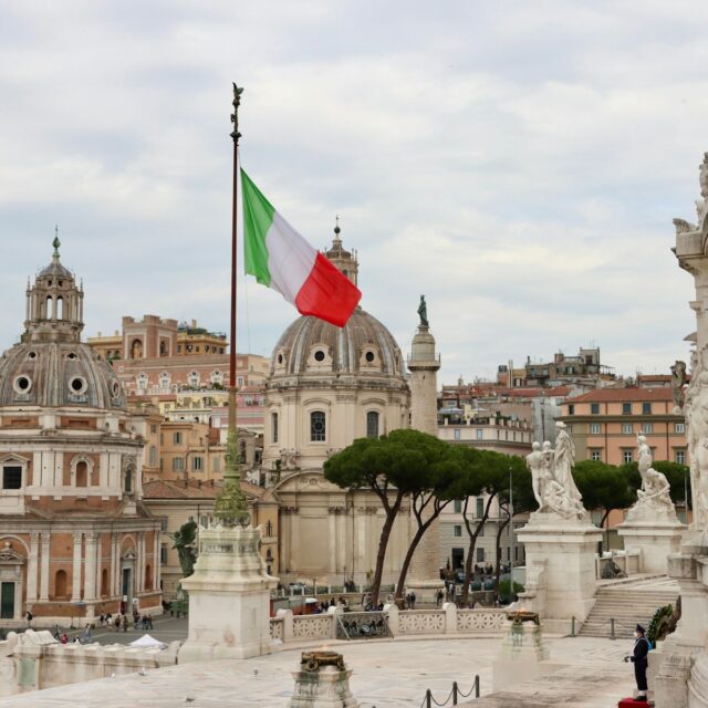 a flag flying in the air over a city