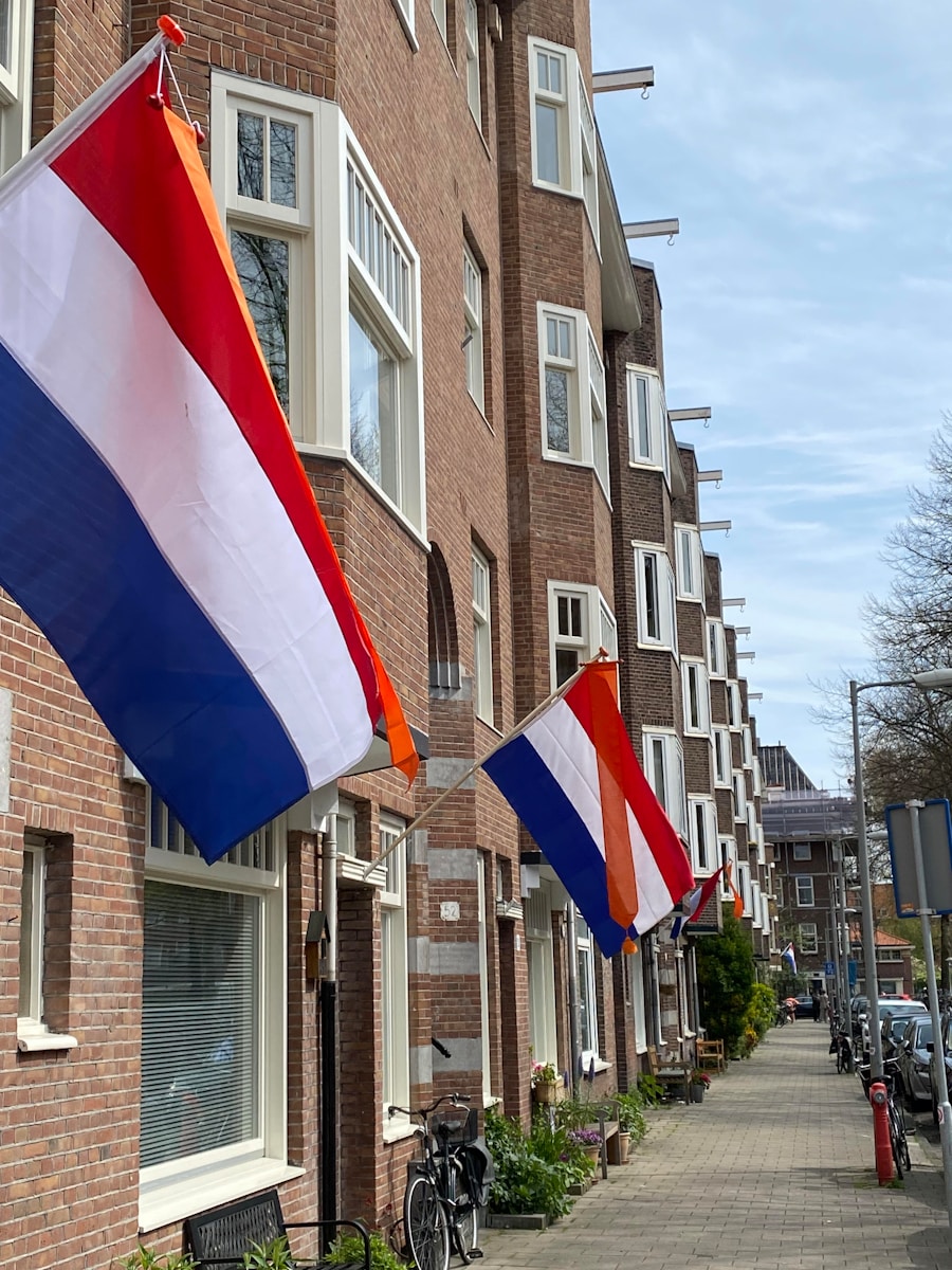 A row of brick buildings with flags hanging from the windows