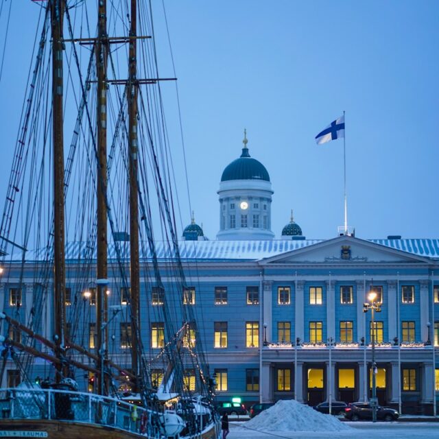 a boat is docked in front of a large building